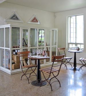 Tables constructed from oak vat tops on cast iron pedestals. Painted white antique display cabinet.